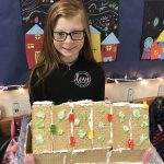 student with gingerbread house